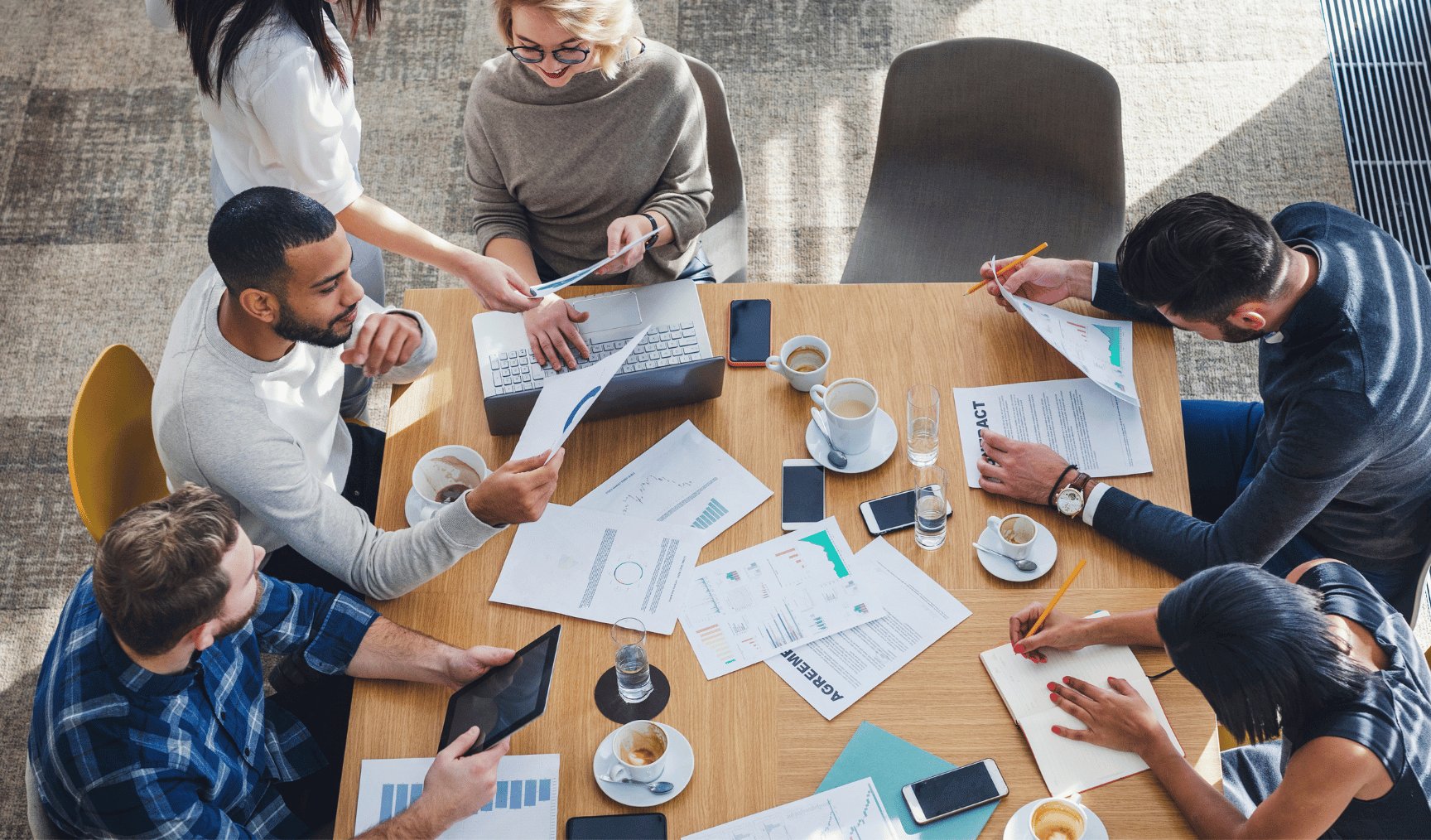 a group of payroll professionals discussing business around a desk